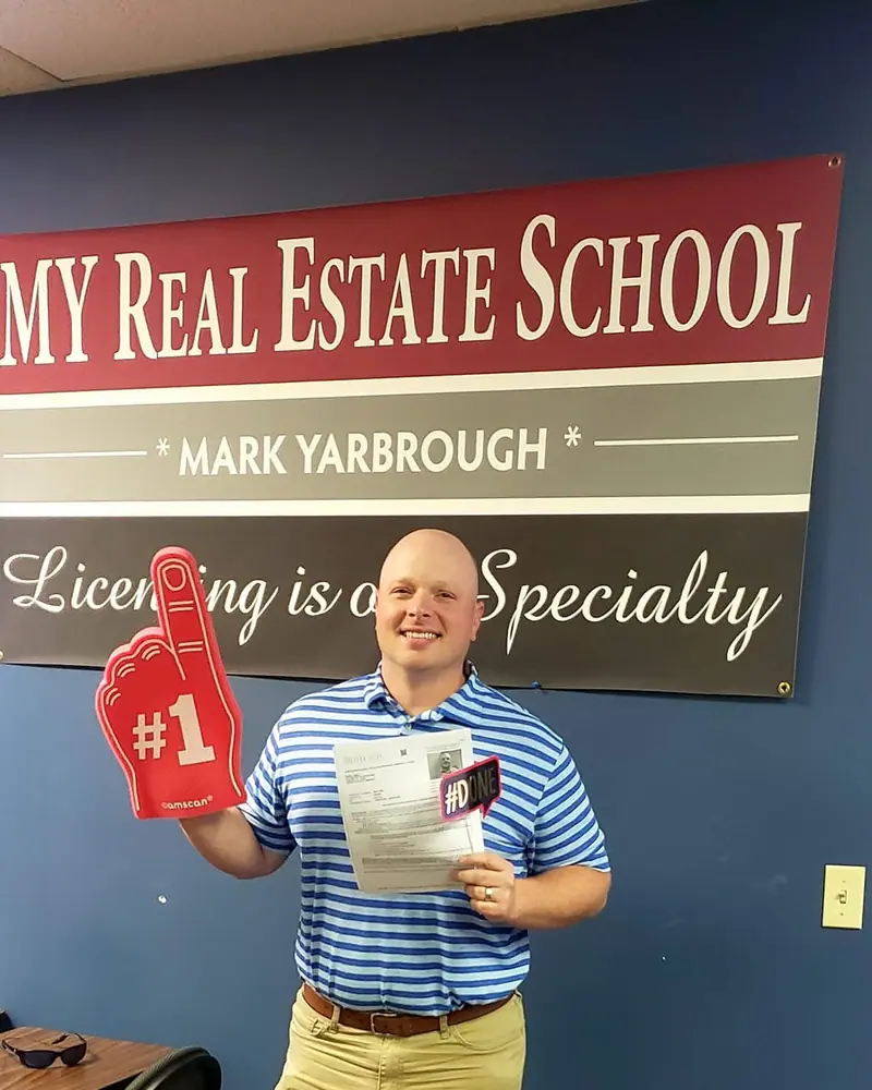 A MY Real Estate School student holding a #1 foam finger and a passing real estate exam score