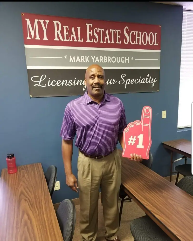 A student with a #1 foam finger and a passing exam score report