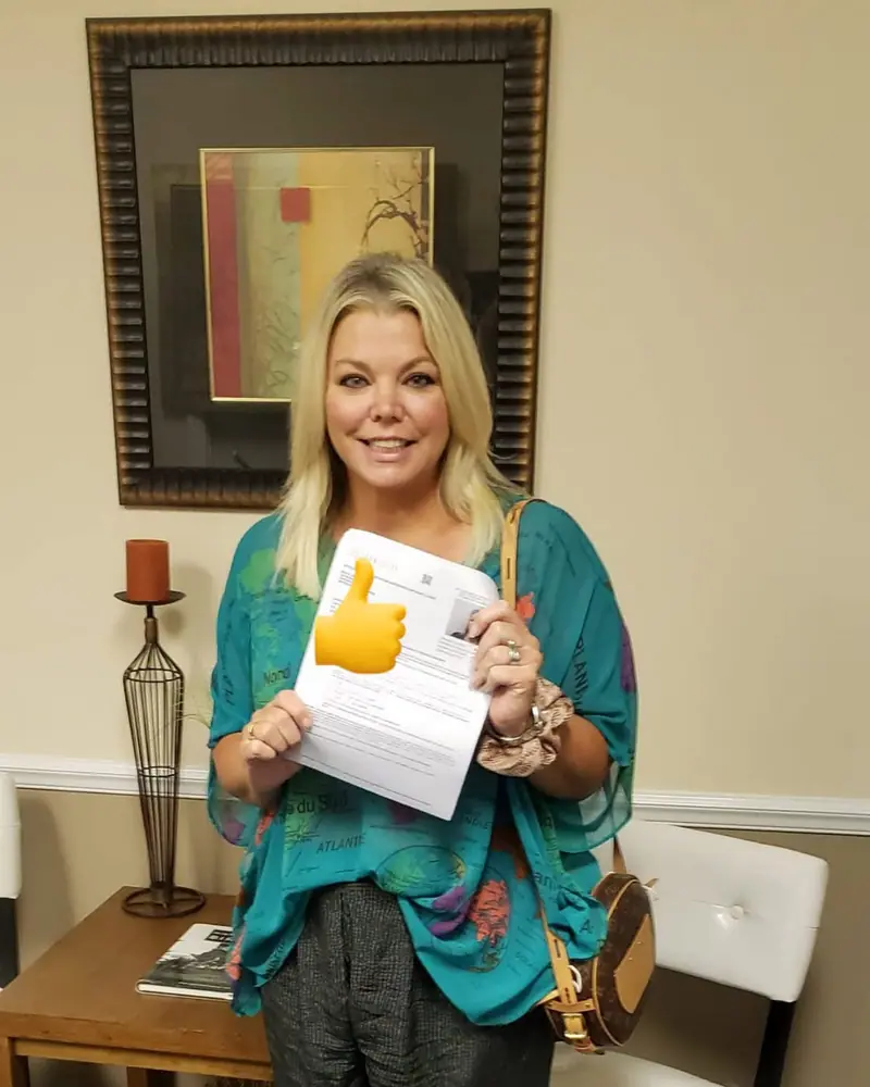 A student giving a thumbs up with her passing exam score